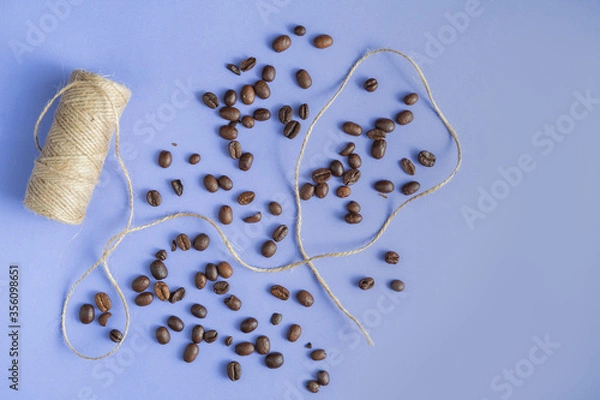 Fototapeta Jute twine and fresh coffee beans on the purple table background, 