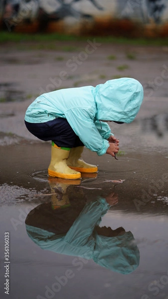 Fototapeta Portrait of a little boy in a hood with earthworm