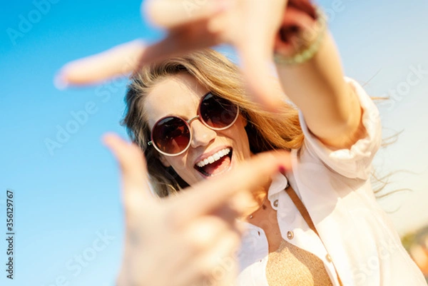 Obraz Happy young tourist smiling with sunglasses and camera