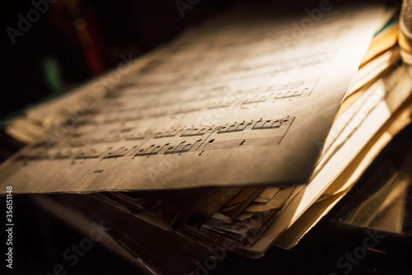 Fototapeta old sheet music in a stack, dimmed lighting