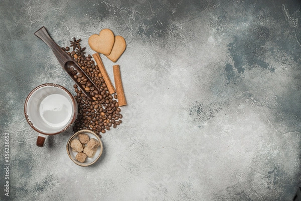 Fototapeta Top view of a Cup of coffee, cappuccino on a table with coffee beans with a wooden spoon