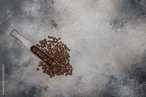 Fototapeta Coffee beans with a wooden spoon and cinnamon sticks
