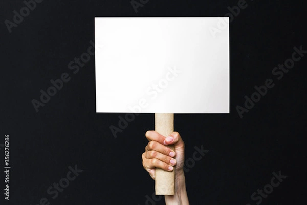 Obraz activist with an empty poster. protest banner on black background
