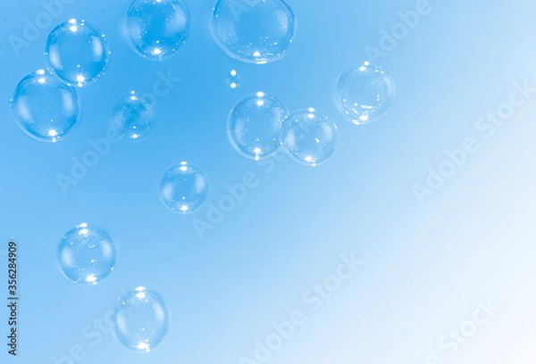 Fototapeta Beautiful blue soap bubbles float as background.
