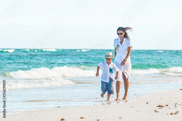 Obraz Mujer y niño con ropa de verano pasea juntos en playa del mar Caribe durante las vacaciones.