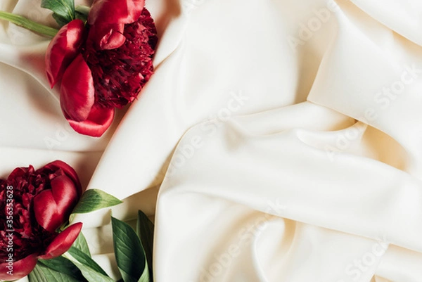 Obraz top view of bouquet of red peonies on white cloth