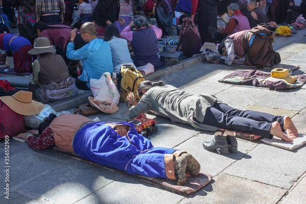 Fototapeta People praying in prostration in front of Jokhang temple in Lhasa on Barkhor square, Tibet