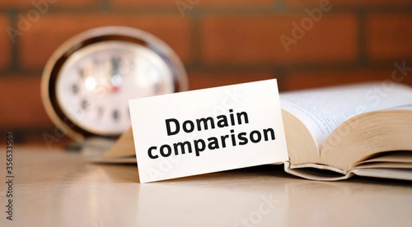 Fototapeta Domain comparison concept text on a white background with a clock and an open book