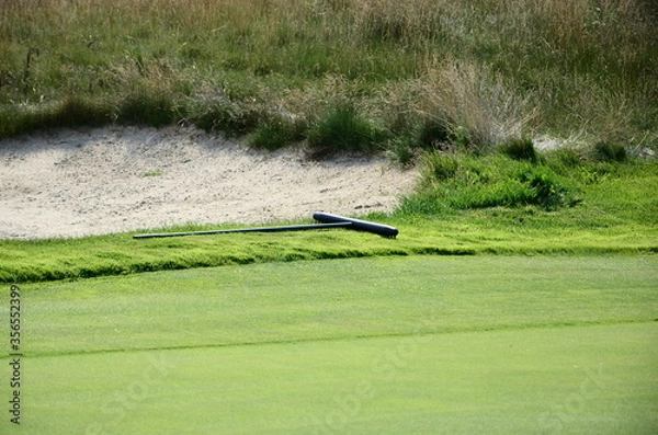 Obraz Green grass and rake on a golf course