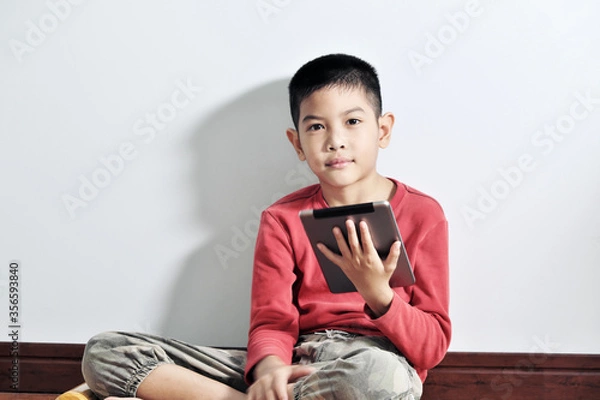 Obraz A boy playing a tablet on a white background