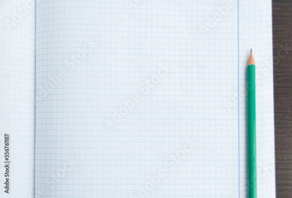 Fototapeta Back to school, education concept. Blank notebook page with a pencil on the wooden table. Design mockup. Copy space. Top view. Flat lay