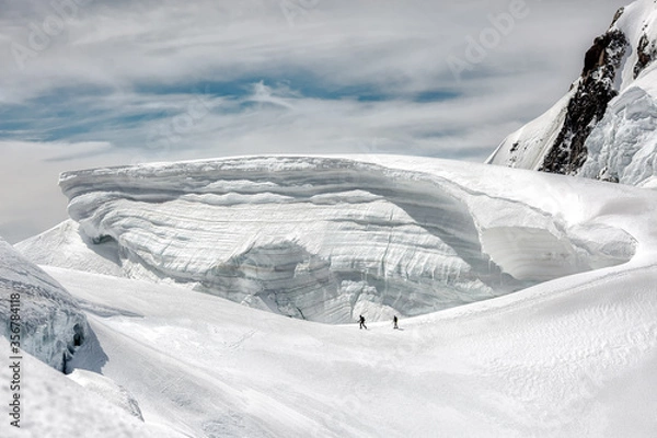 Obraz two climbers go in danger under a large glacier 