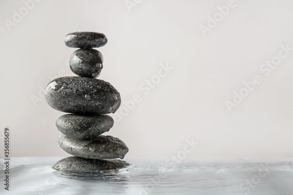 Fototapeta Spa stones in water against light background