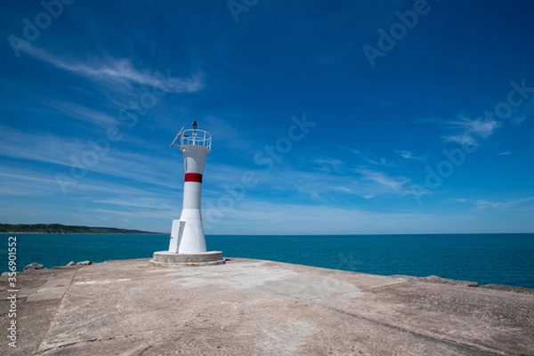 Fototapeta Lighthouse on the blue sky background. Wide angle wiew