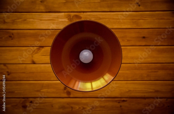 Obraz metal chandelier with a white light bulb on a wooden ceiling