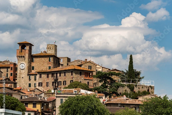 Fototapeta 
View of an ancient ancient italian with towers and bell tower, blue sky and clouds background
