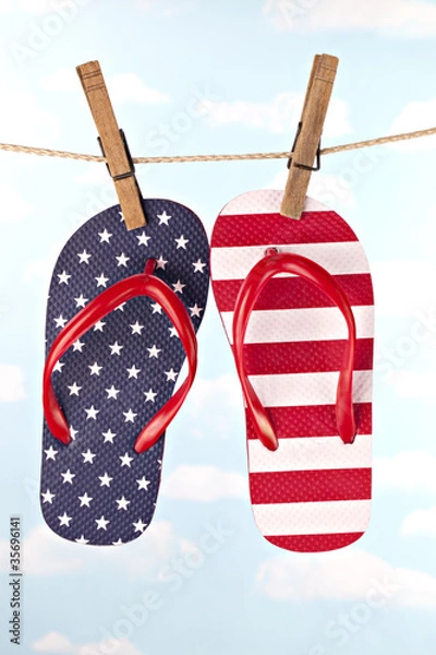 Fototapeta Flag patterned flip flop shoes hanging on clothes line