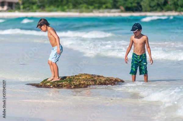 Obraz Dos niños exploran en la playa durante vacaciones de verano en el Caribe