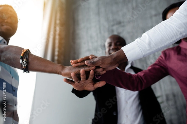 Obraz Bottom view of black colleagues who joined hands for hard team work against racism among countries of the world.
