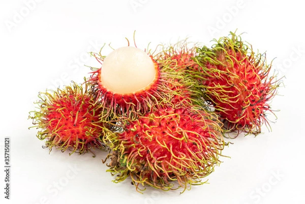 Fototapeta Small group of rambutanSmall group of rambutan with one peeled half rambutan put on top. Isolated close up image on white background. Close up tropical fruits of Thailand.