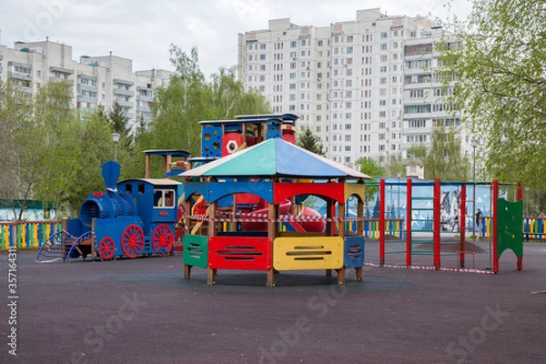 Fototapeta Playground in the courtyard of a residential building, children's steam locomotive, closed for quarantine
