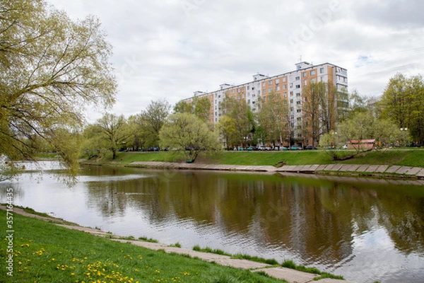 Fototapeta Multi-storey residential building near the pond