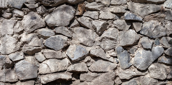 Fototapeta background, texture of a gray stone wall made of large stones, panorama