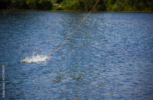 Fototapeta The handle that you hold while riding a wakeboard jumps on the water