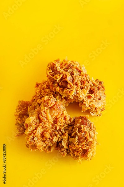 Fototapeta Crispy fried chicken against a bright yellow background