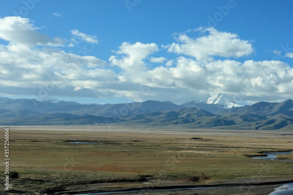 Fototapeta First view on Kailash Mountain rising from Barkha plain from the road from the distance with fields in front