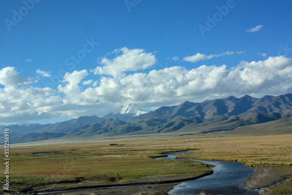 Fototapeta First view on Kailash Mountain rising from Barkha plain from the road from the distance with fields in front with river