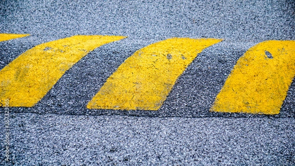 Fototapeta Speed bumps in a Road are the common name for a family of traffic calming devices that use vertical deflection to slow motor-vehicle traffic in order to improve safety conditions.