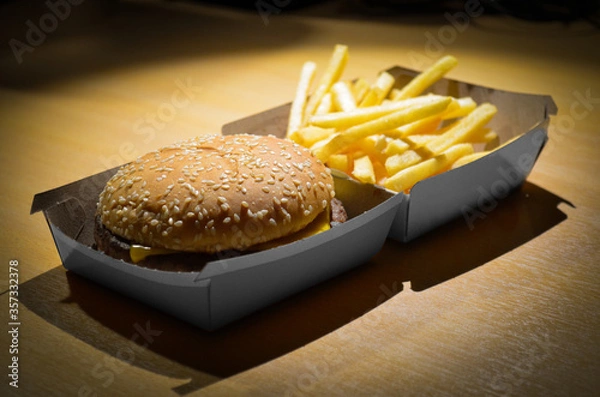 Obraz A fast-food restaurant hamburger (cheeseburger) with fries