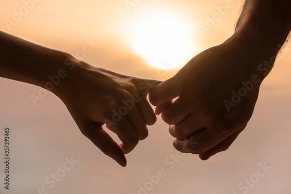 Fototapeta a couple hold each other's hands in the background of the sunset