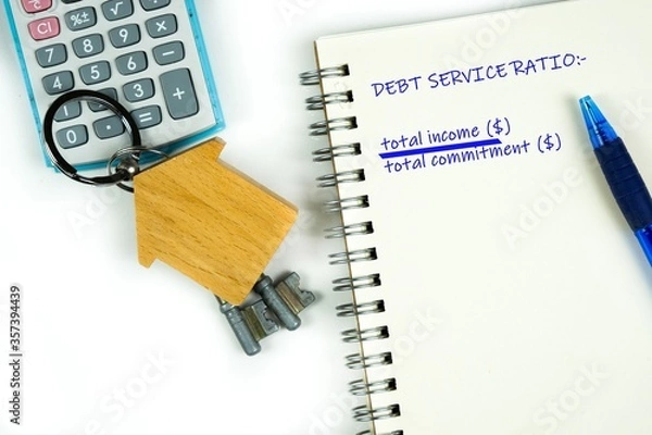 Fototapeta Conceptual image of debt service ratio for home loan repayment appraisal. Wooden key chain calculator notepad and pen in visibility. Focus on keychain.