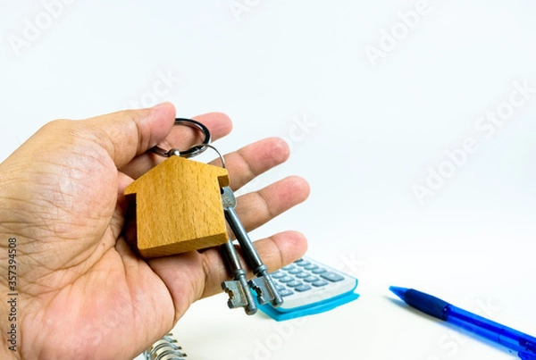 Fototapeta Conceptual image of debt service ratio for home loan repayment appraisal. Wooden key chain calculator notepad and pen in visibility. Focus on keychain.