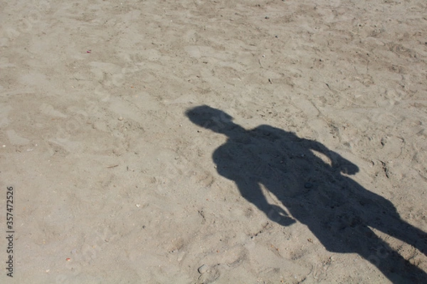 Fototapeta Shadow of man standing on sand background.