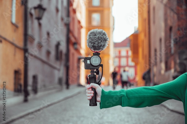 Obraz Ręcznie trzymanie aparatu z mikrofonem, vlogger z kamerą nagrywającym blog wideo, narzędzia do tworzenia treści
