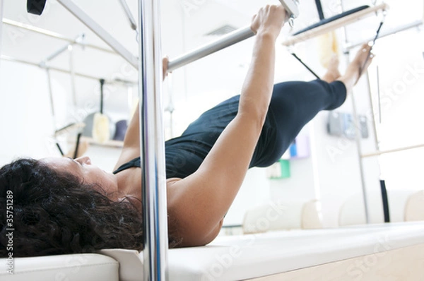 Obraz Attractive young lady doing pilates