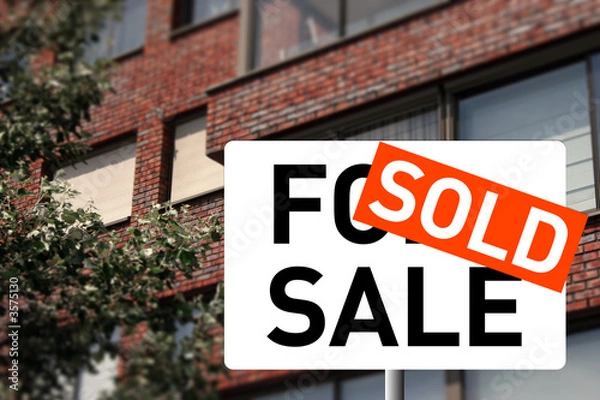 Fototapeta A sold sign and a house on the background