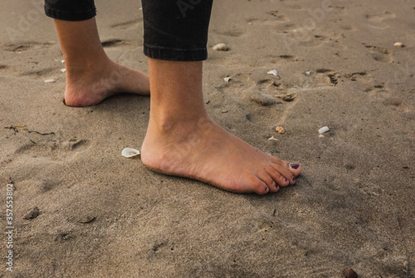 Obraz Sandy Feet surrounded by shells on a summers day at the beach
