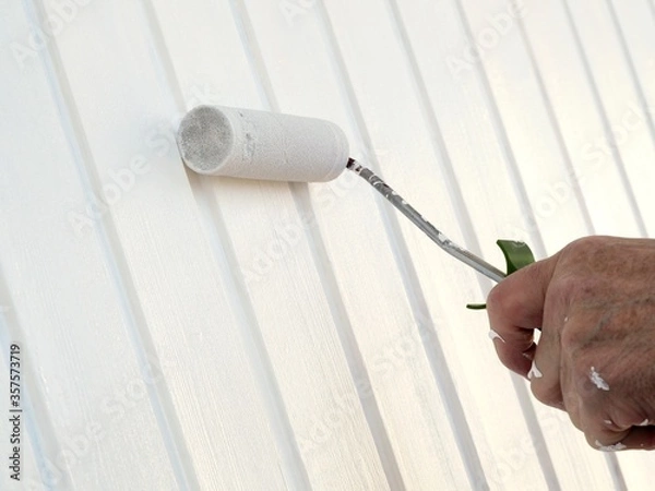 Obraz Mann streicht Garagentor in Weiß
