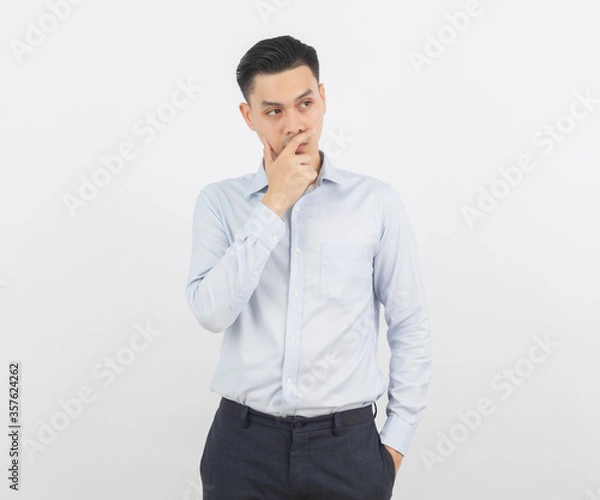 Fototapeta Young handsome asian business man thinking an idea while looking up isolated on white background.