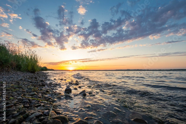 Obraz sunset with clouds on a stony beach