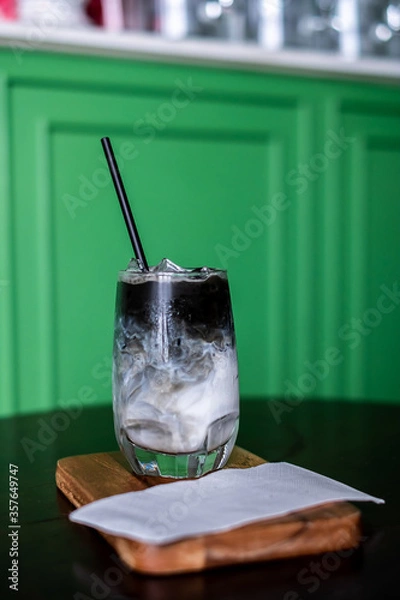 Fototapeta Iced coffee mixed with milk together served in a glass on wood