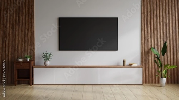 Obraz Large TV on the wall. The white room on the side decorated with wood, with trees and books on the table.3D Rendering.
