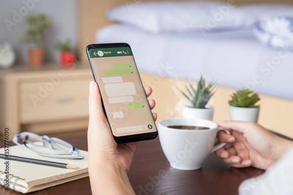 Fototapeta kobieta ręka trzyma mobilny smartfon z makietą ekranu wiadomości czatu w aplikacji społecznościowej. szablon okna dialogowego dymek z miejscem na tekst