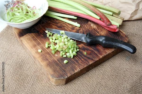 Fototapeta Fresh rhubarb sliced on a cutting board. There is a place for text.
rhubarb on wooden surface