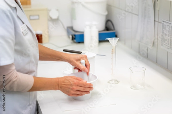 Fototapeta close up view of a pharmacist in the laboratory mixing a medical ointment in a bowl
