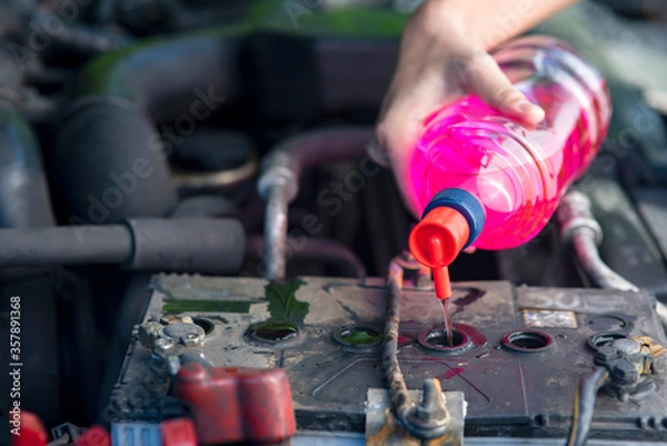 Fototapeta  Hand on Add distilled water battery Concept to maintain and maintain vehicles